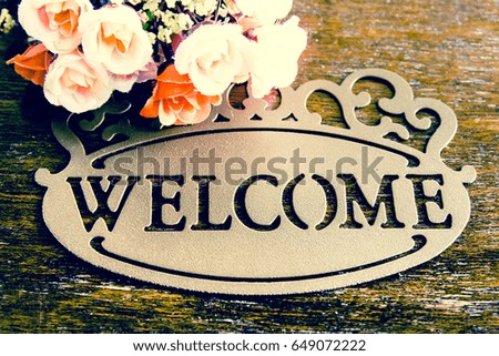 Welcome sign and roses on wooden background,Vintage