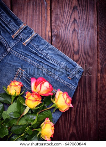 bouquet of fresh yellow roses lying on the blue jeans