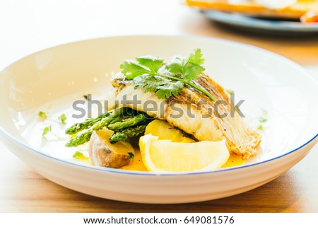 Grilled Barramundi or pangasius fish and meat steak with vegetable and lemon in plate - Healthy food style