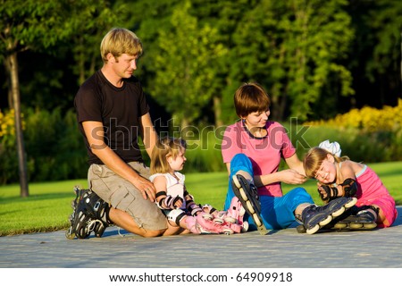 Cheerful parents and kids in roller skates