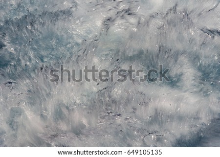 Moving effect on foam of Blue ocean waves background texture detail