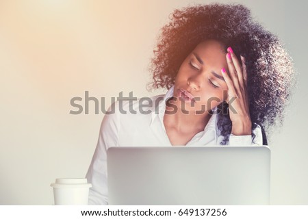 Portrait of a stressed out African American businesswoman sleeping at work. Concept of workaholism. Toned image Royalty-Free Stock Photo #649137256