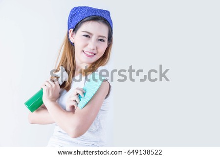young Asian housewife cross arms holding rag and sprayer cleaning with copy space on background. Housekeeping and household concept.