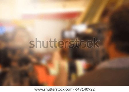 out of focus video and camera operators recording video and photos at an event