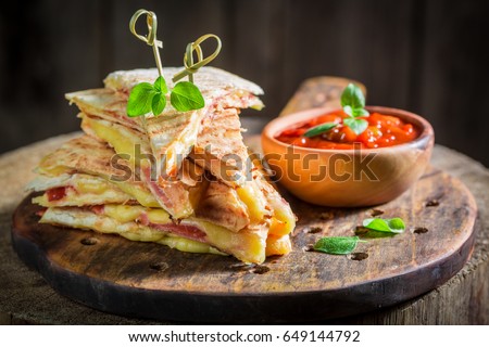 Spicy quesadilla made of tortilla with cheese and ham