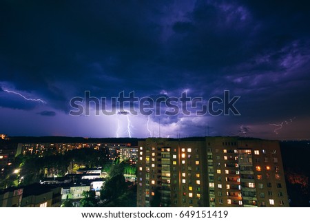 Thunderstorm and lightning over a small city at night. Ukraine. Beautiful purple dark sky.