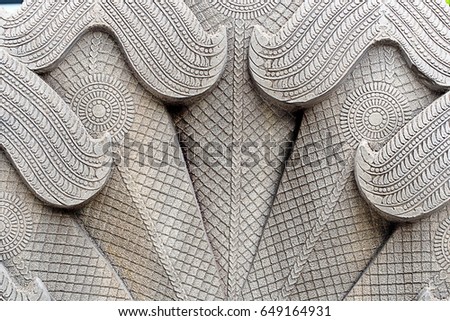 Stucco pattern behind the serpent, up the steps of the temple in Thailand.