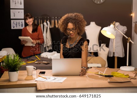 Two young entrepreneur women, and fashion designer working on her atelier Royalty-Free Stock Photo #649171825