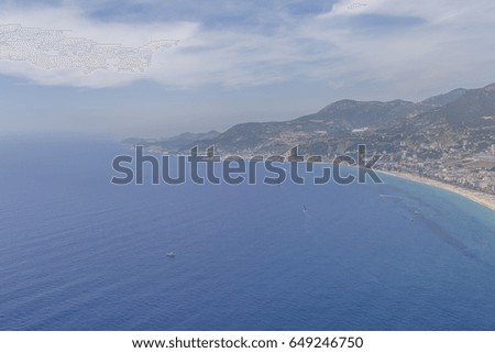 A bird's eye view of a Mediterranean town located on the coast of a warm blue clear clear sea.