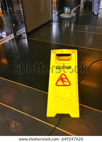 Yellow slippery floor sign in front of elevator