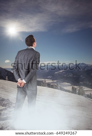 Digital composite of Business man with mist standing looking at mountains