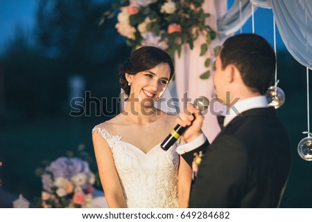 The groom keeps a microphone and speeking to his bride