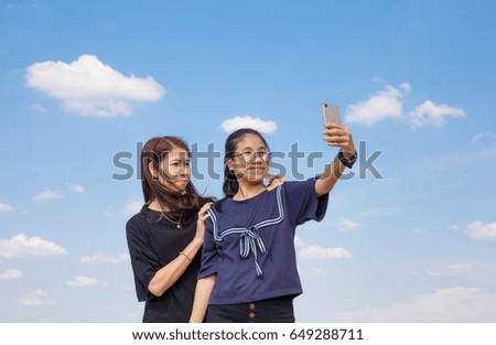 Selfie girl with her mother by phone.