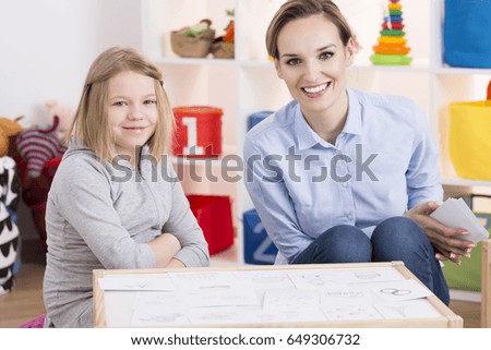 Female special educator and child patient during therapy using pictures