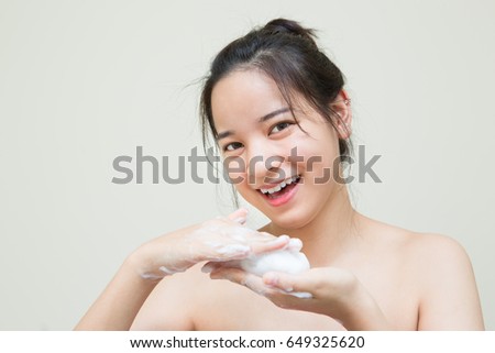 cute Asian girl teenager age rub bubble of soap foam at her hands and she smiles   Royalty-Free Stock Photo #649325620