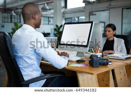 Graphic designers working at desk in office