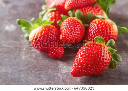 Fresh red strawberry with green leaves. Dark background. Ingredients for smoothies