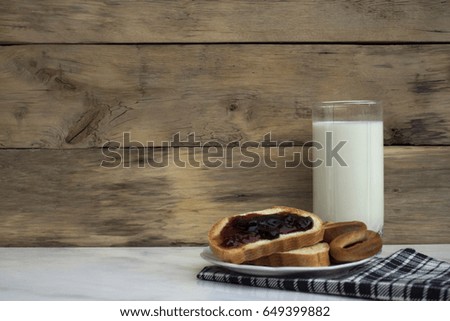Picture of a meal in a rustic style. A glass of milk with slices
