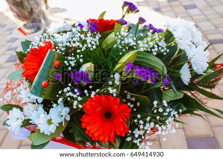 The flowers in the bouquet. Red, white and purple flowers.