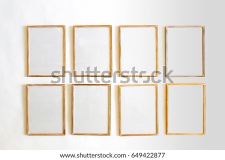 a lot of blank wooden picture frames or canvas hang on white wall