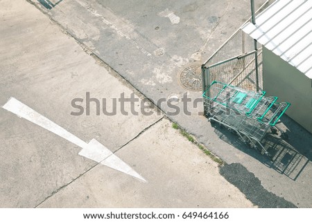The cart of supermarket stop still park on ground in area outside store supermarket, take a shoot with top view.