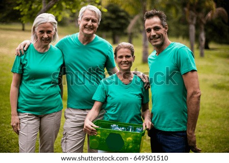 Portrait of recycling team members standing in park