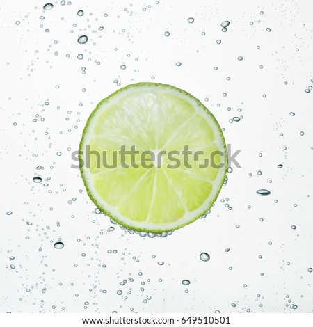 Slice of lime is in the water bubbles