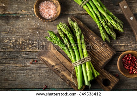 banches of fresh green asparagus on wooden background, top view Royalty-Free Stock Photo #649536412