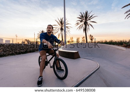 Shot of a man doing tricks on his bike, with sun flare.