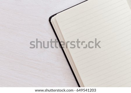 Blank notepad on white wooden desk background