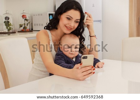 young mother and her son play and reading a book on sofa, lifestyle, real interior