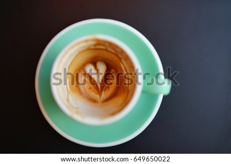 Latte art "Heart" at the bottom of green cup