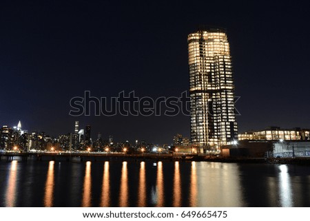 Under Construction Building and Pier at Night With New York Skyline in Background