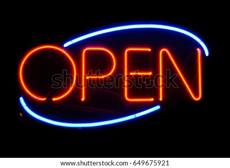 Open neon sign hanging in a window