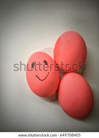 Three pink egg put on white background ,one of pink egg smile,look happy.