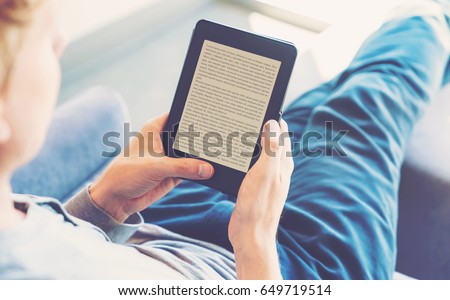 Man reading an e-book on digital tablet device Royalty-Free Stock Photo #649719514