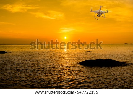 drone copter flying with digital camera.Drone with high resolution digital camera. Flying camera take a photo and video.The drone with professional camera takes pictures of the Twilight Sea.