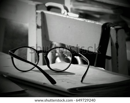 A pair of glasses on a notebook in a classroom. Black and white photography. Clever or intelligence concept.