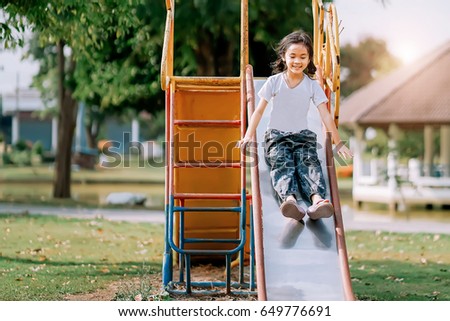  Asian little girl isplaying at amusement park player in the morning ,Learning skills concept.