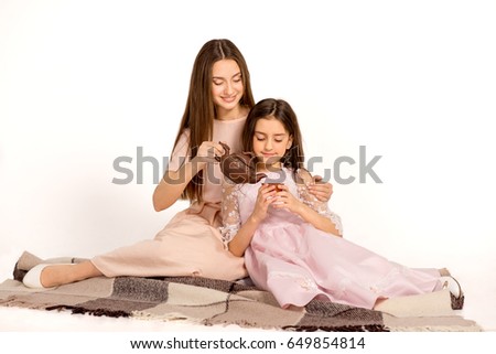 Young pretty girls on isolated background. Young girls with kettle on isolated background.  Family tea ceremony. Pretty sisters. 
A pajamas party with beautiful sisters