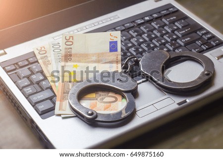 handcuff and money on the laptop