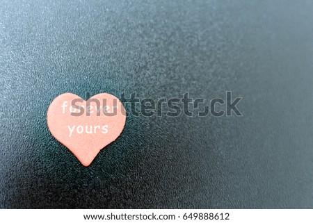 red heart with inscription on black Board.