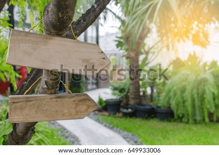 empty wooden signs for text with view of the green garden, selective focus, sunlight effect.