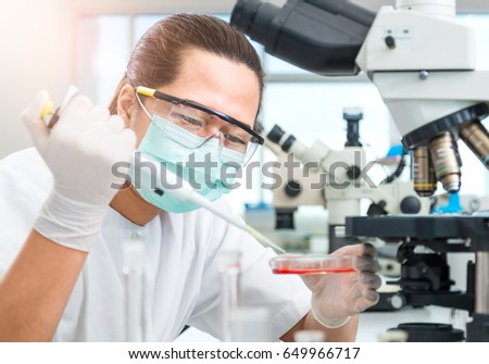 Women Scientist checking test sample with microscope