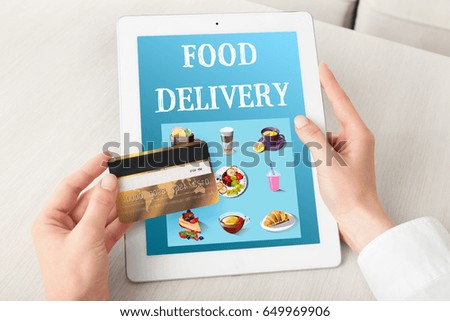 Food delivery concept. Woman using tablet and credit card for ordering dinner online
