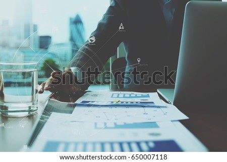businessman working with mobile phone and digital tablet and laptop computer on wooden desk in modern office with VR icon and chart diagram
