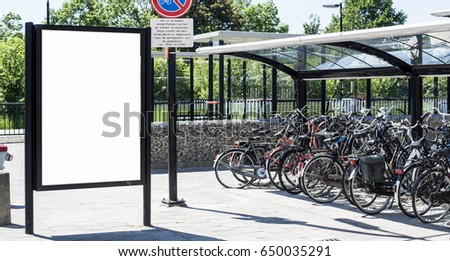 Outdoor advertising abri or billboard at station with bicycles 