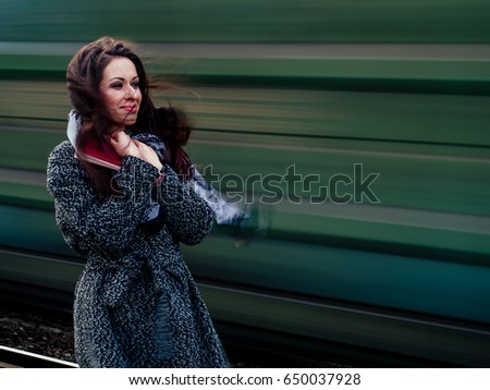 Girl near a blurred train. Travel, adventure, rest - concept, idea