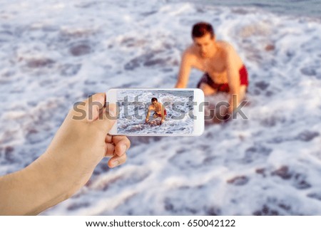 Man filming with his phone as a swimmer drowned