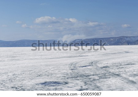 Baikal lake spring landscape view. Snow-covered surface of the ice lake. Winter.